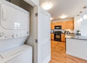 Thumbnail 35 of 104 - A white washing machine and dryer in a kitchen at The Grand Apartments, Oakland 94612